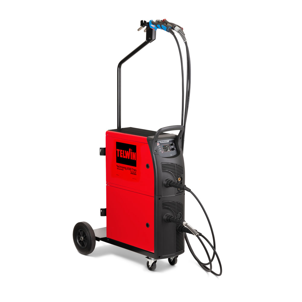 Werkzeuge – Qualität für Profis Das rot-schwarze Schweißgerät TELWIN TECHNOMIG 223 TREO SYN auf Rädern ist auf weißem Hintergrund abgebildet und verfügt über Kabel und ein detailliertes Bedienfeld. Es wird mit 230 V betrieben und unterstützt die SPOOL GUN für präzise Schweißarbeiten. Jetzt kaufen