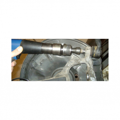 Werkzeuge – Qualität für Profis Eine Hand bedient gekonnt einen Condor Druckluft-Meißelhammer mit Schnellkupplung an einem Metallbauteil, im Hintergrund sind ein Akkuschrauber-Set und ein großes rundes Objekt zu sehen. Jetzt kaufen