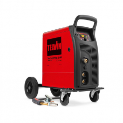 Werkzeuge – Qualität für Profis Ein rot-schwarzes TELWIN TECHNOMIG 241 WAVE 230V Schweißgerät mit Rädern und angebrachten Kabeln steht auf dem Boden. Telwin Schweißgeräte bieten ein optimales Preis/Leistungsverhältnis. Jetzt kaufen