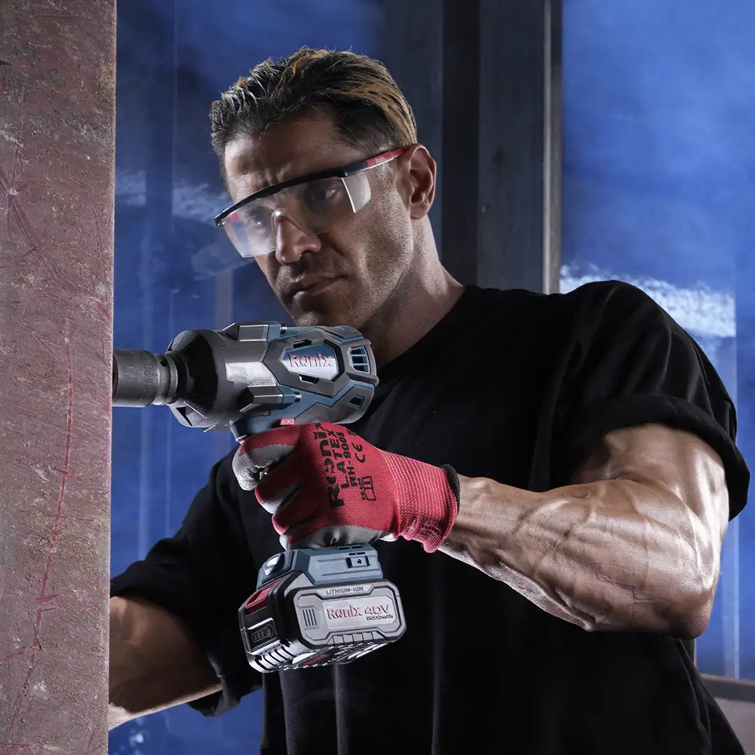 Werkzeuge – Qualität für Profis Eine Person, die eine Schutzbrille und Handschuhe trägt, bearbeitet mit einer Akku-Bohrmaschine von Bosch einen Betonpfeiler in einer Industrieumgebung. Jetzt kaufen